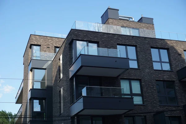 stock image Warsaw, Poland, June 26th 2022 - Modern residential building with balconies and dark brick facade. Real estate and housing issues concept.