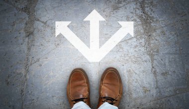 Kahverengi deri ayakkabılar ve asfaltta tebeşirli oklar - seçim kavramı