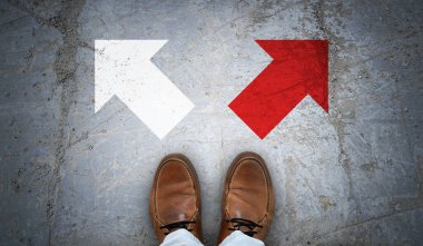 Kahverengi deri ayakkabılar ve asfalt üzerinde iki sağ ve sol tebeşir ok- seçmeli kavram