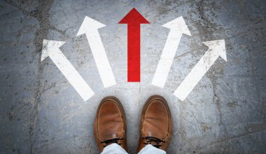 Kahverengi deri ayakkabılar ve asfalt üzerinde beş tebeşir ok- seçim kavramı