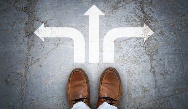 Kahverengi deri ayakkabılar ve asfalt üzerinde üç tebeşir ok- karar konsepti