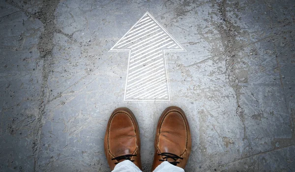 stock image Brown leather shoes and chalky arrow on asphalt - forward concept