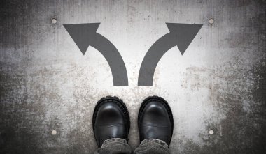 Ağır siyah deri çizmeler ve yerde iki sağ ve sol ok - seçmeli kavram