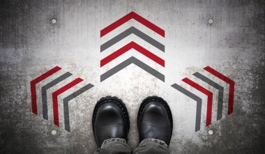 Ağır siyah deri çizmeler ve yerde üç ok - karar konsepti