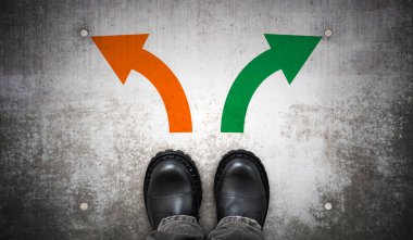 Ağır siyah deri çizmeler ve yerde iki renkli ok - seçim konsepti