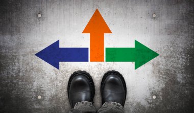 Ağır siyah deri çizmeler ve yerde üç renkli ok - strateji kavramı