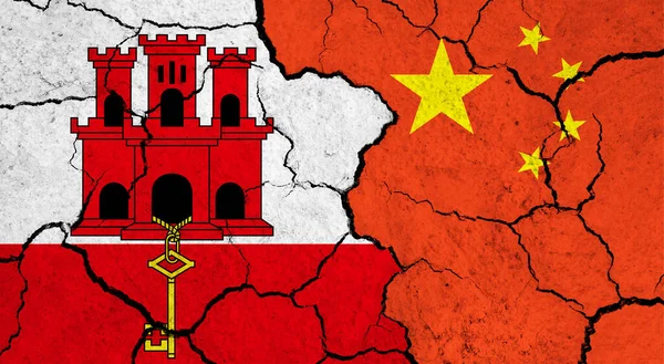 Flags of Gibraltar and China on cracked surface - politics, relationship concept