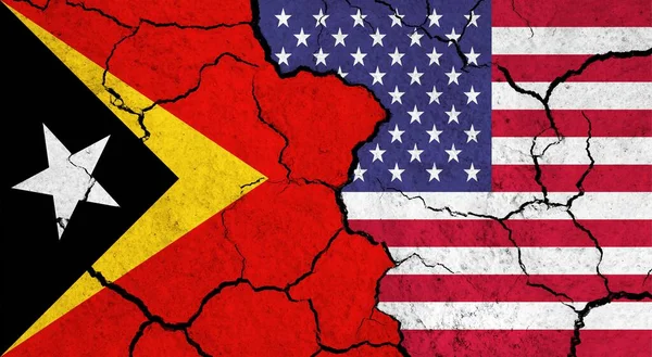 Flags of East Timor and USA on cracked surface - politics, relationship concept