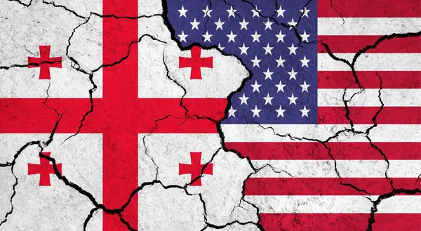 Flags of Georgia and USA on cracked surface - politics, relationship concept