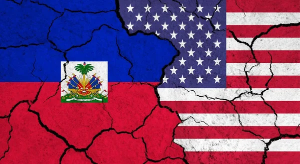 Flags of Haiti and USA on cracked surface - politics, relationship concept