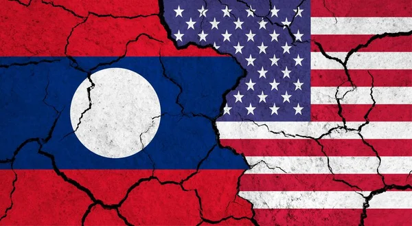 Flags of Laos and USA on cracked surface - politics, relationship concept