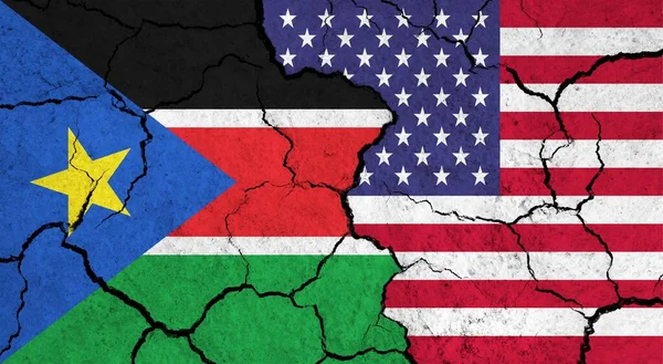 Flags of South Sudan and USA on cracked surface - politics, relationship concept