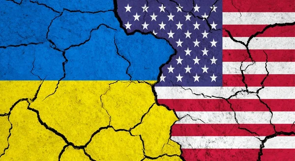 Flags of Ukraine and USA on cracked surface - politics, relationship concept