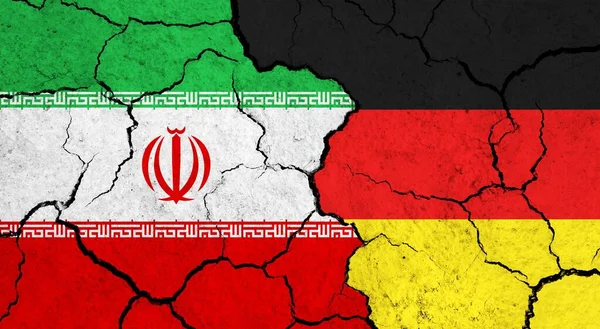 Flags of Iran and Germany on cracked surface - politics, relationship concept