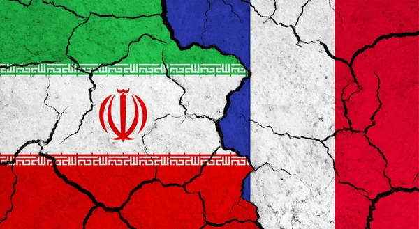 Flags of Iran and France on cracked surface - politics, relationship concept