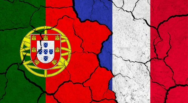 Flags of Portugal and France on cracked surface - politics, relationship concept