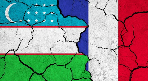 Vlaggen Van Oezbekistan Frankrijk Gebarsten Oppervlak Politiek Relatieconcept — Stockfoto
