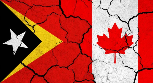 Flags of East Timor and Canada on cracked surface - politics, relationship concept