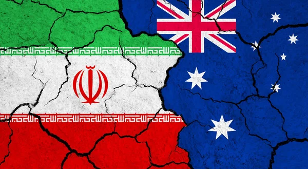 Flags of Iran and Australia on cracked surface - politics, relationship concept