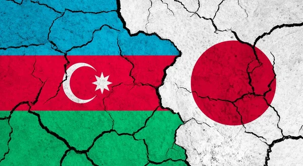 Flags of Azerbaijan and Japan on cracked surface - politics, relationship concept