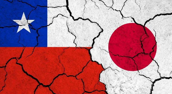 Flags of Chile and Japan on cracked surface - politics, relationship concept