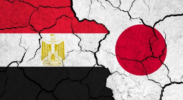 Flags of Egypt and Japan on cracked surface - politics, relationship concept