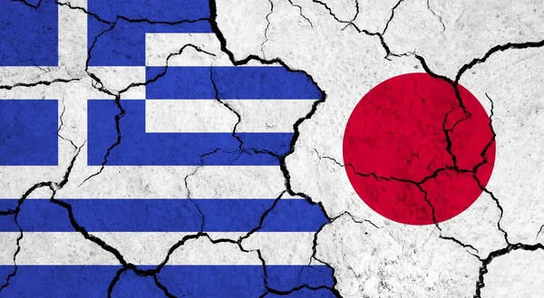 Flags of Greece and Japan on cracked surface - politics, relationship concept