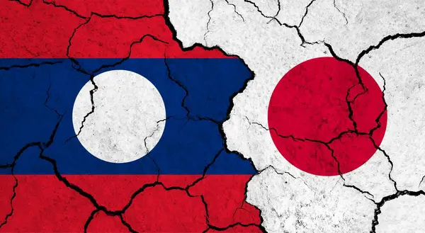 Flags of Laos and Japan on cracked surface - politics, relationship concept