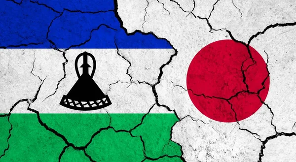 Flags of Lesotho and Japan on cracked surface - politics, relationship concept