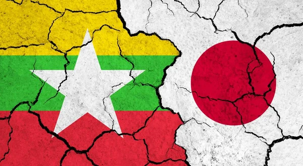 Flags of Myanmar and Japan on cracked surface - politics, relationship concept