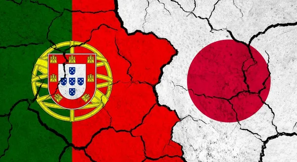 Flags of Portugal and Japan on cracked surface - politics, relationship concept