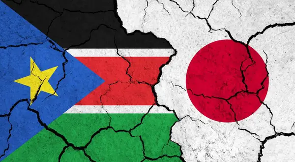 Flags of South Sudan and Japan on cracked surface - politics, relationship concept