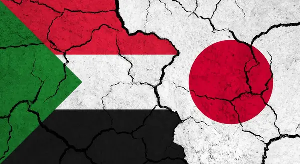 Flags of Sudan and Japan on cracked surface - politics, relationship concept