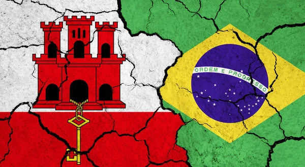 Flags of Gibraltar and Brazil on cracked surface - politics, relationship concept