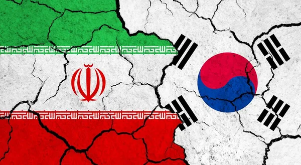 Flags of Iran and South Korea on cracked surface - politics, relationship concept