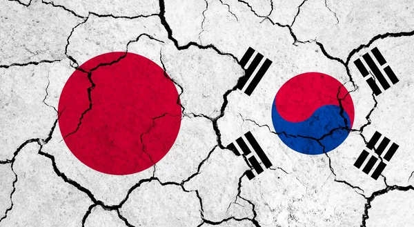 Flags of Japan and South Korea on cracked surface - politics, relationship concept