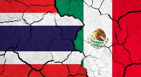 Flags of Thailand and Mexico on cracked surface - politics, relationship concept