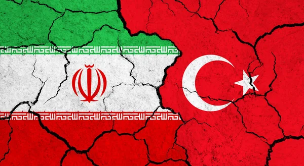 Flags of Iran and Turkey on cracked surface - politics, relationship concept