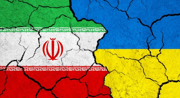 Flags of Iran and Ukraine on cracked surface - politics, relationship concept