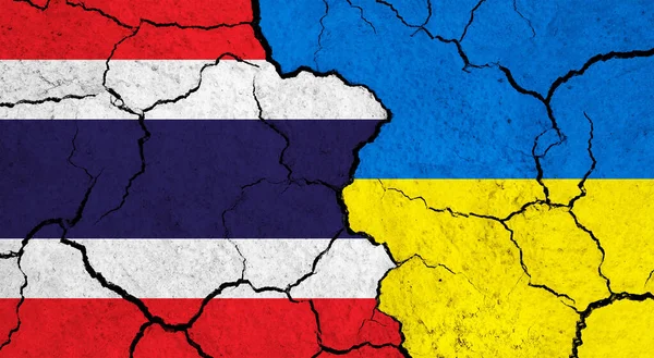 Flags of Thailand and Ukraine on cracked surface - politics, relationship concept