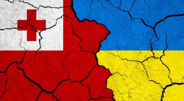 stock image Flags of Tonga and Ukraine on cracked surface - politics, relationship concept