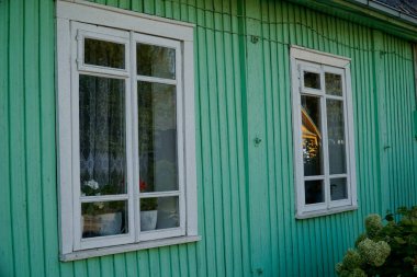 Trakai, Litvanya - 9 Eylül 2023 - Geleneksel tahta Karaim evi yeşile boyanmış - pencerelere yakın plan