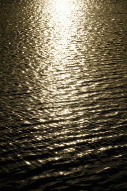 Güneş gün batımında su yüzeyine yansıyor.