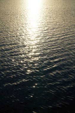 Güneş gün batımında su yüzeyine yansıyor.