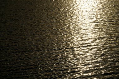 Güneş gün batımında su yüzeyine yansıyor.