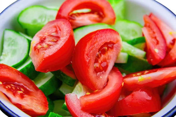 Salad of fresh vegetables sliced tomatoes and cucumbers in a plate. Red tomato. Green cucumber. Vegetable salad. Vegetarian food. Healthy food. The beauty.