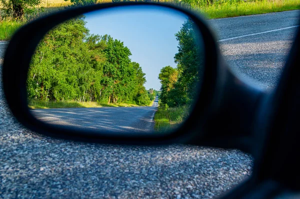 在一条有白色标记的双车道沥青路面上的汽车镜子中的反光 车镜中的倒影 沥青路面 车流的地方 汽车旅游和旅行 美丽的 — 图库照片#