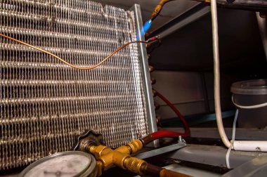 Buzdolabının oksijen kaynaklı bakır borularını lehimliyorum. Oksijen kaynağı. Bakır boruların bağlantısı. Buzdolabı tamiri. Klimaların tamiri. Çalışan endüstriyel araç.