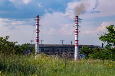 Şehre elektrik sağlayan bir termik santralin bacaları. Pipo iç. Termik santral. Endüstriyel bina. Enerji üretimi. Bulutlu Mavi Gökyüzü. Ekoloji.
