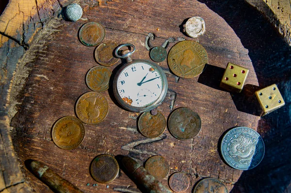 Wooden table for playing dice for money. Throw the dice. Gambling at the table. Pocket watch. Small arms cartridges. Old coins. Time is money. Two fives. Gambling business. The beauty.